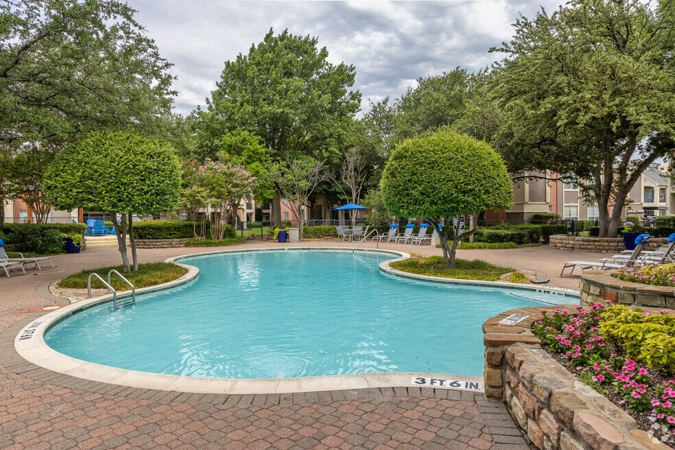 a swimming pool with trees and a fountain