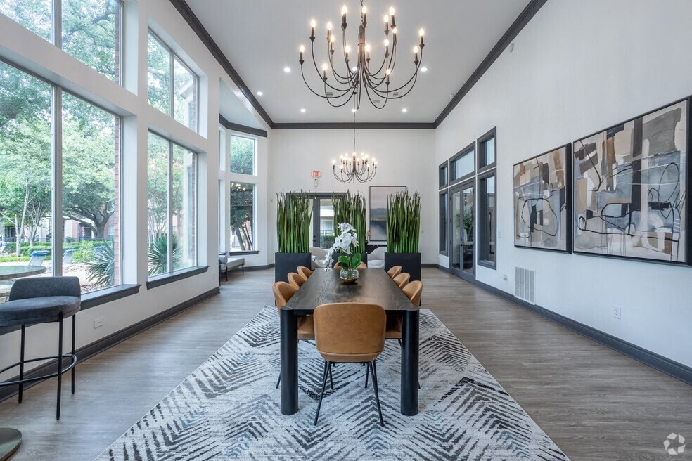 a dining room with large windows and a chandelier