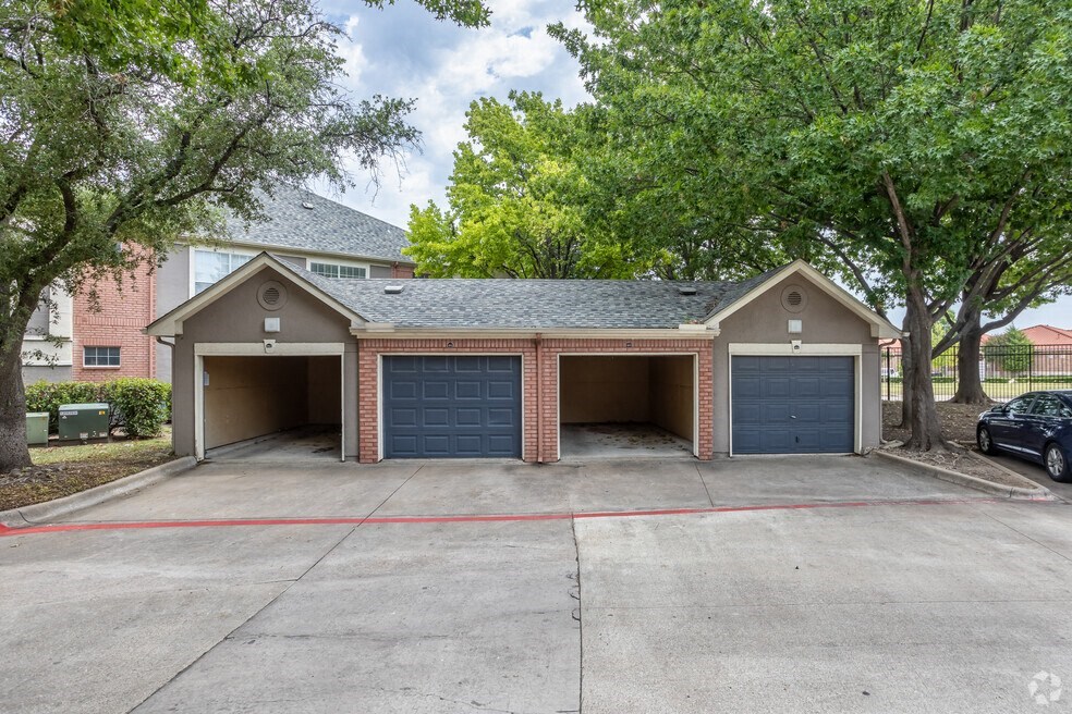 a parking lot with two garages in front of a house