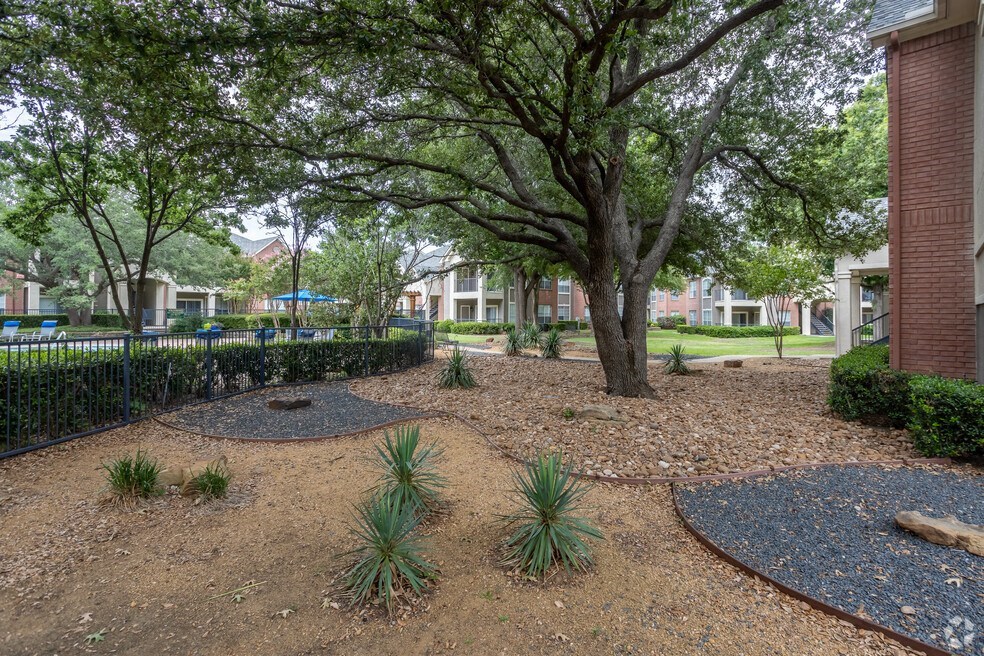 a park with trees and plants in front of a building
