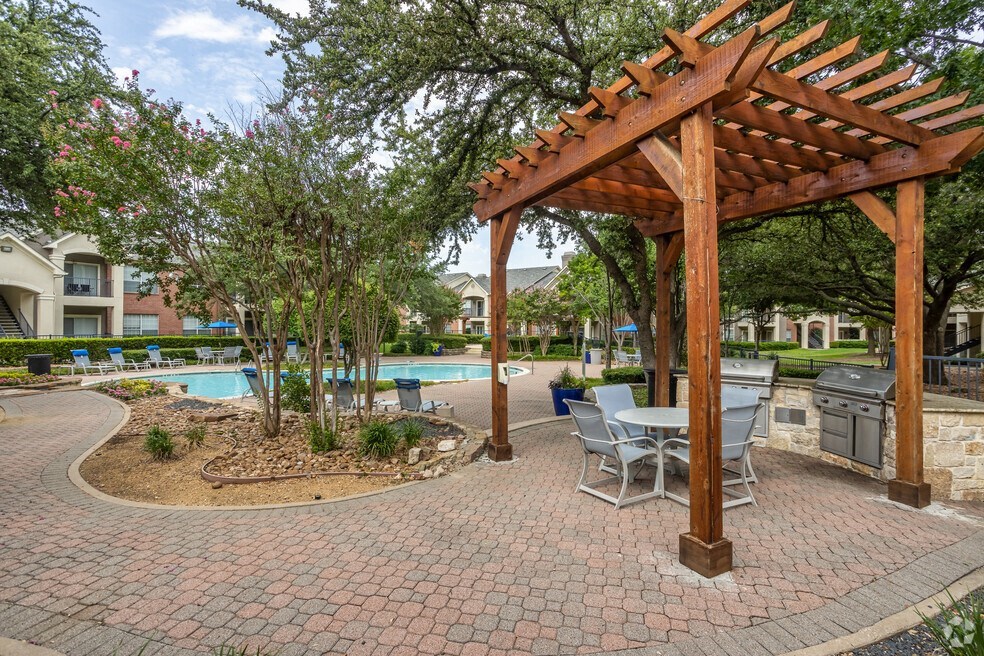 a patio with a pergola and a swimming pool