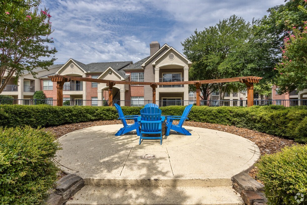 a round patio with blue chairs and a building in the background