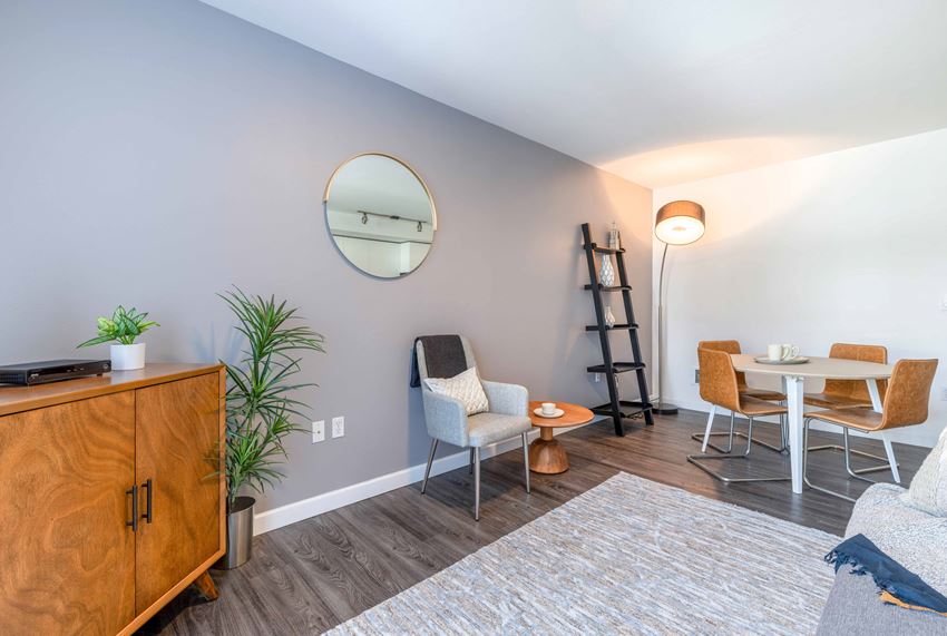 a living room with grey walls and a round mirror on the wall