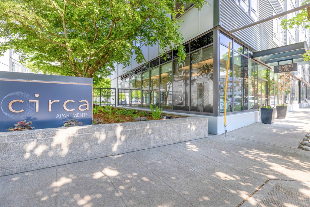 a sign in front of a building with trees in the background