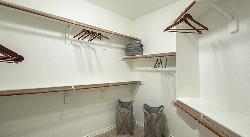 the walk in closet has plenty of hooks and baskets