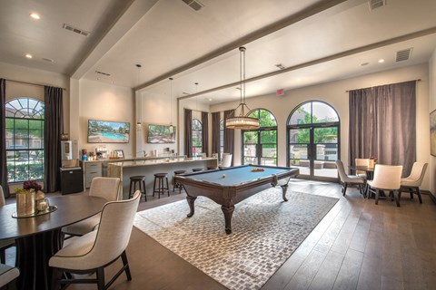 A large room with a pool table and a bar.
