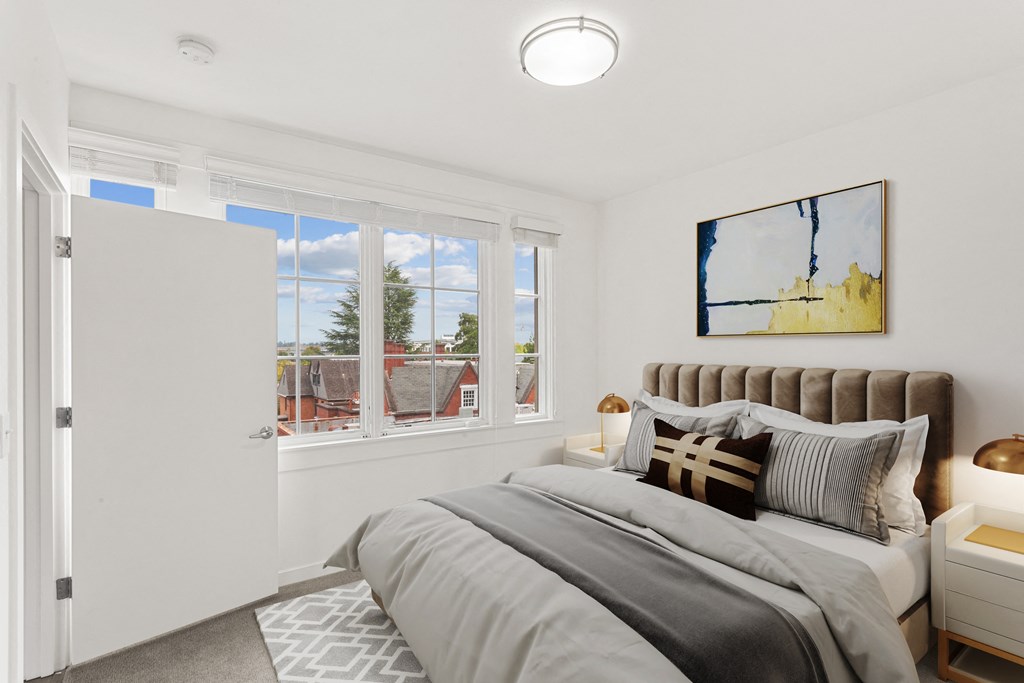 a bedroom with a bed and two windows