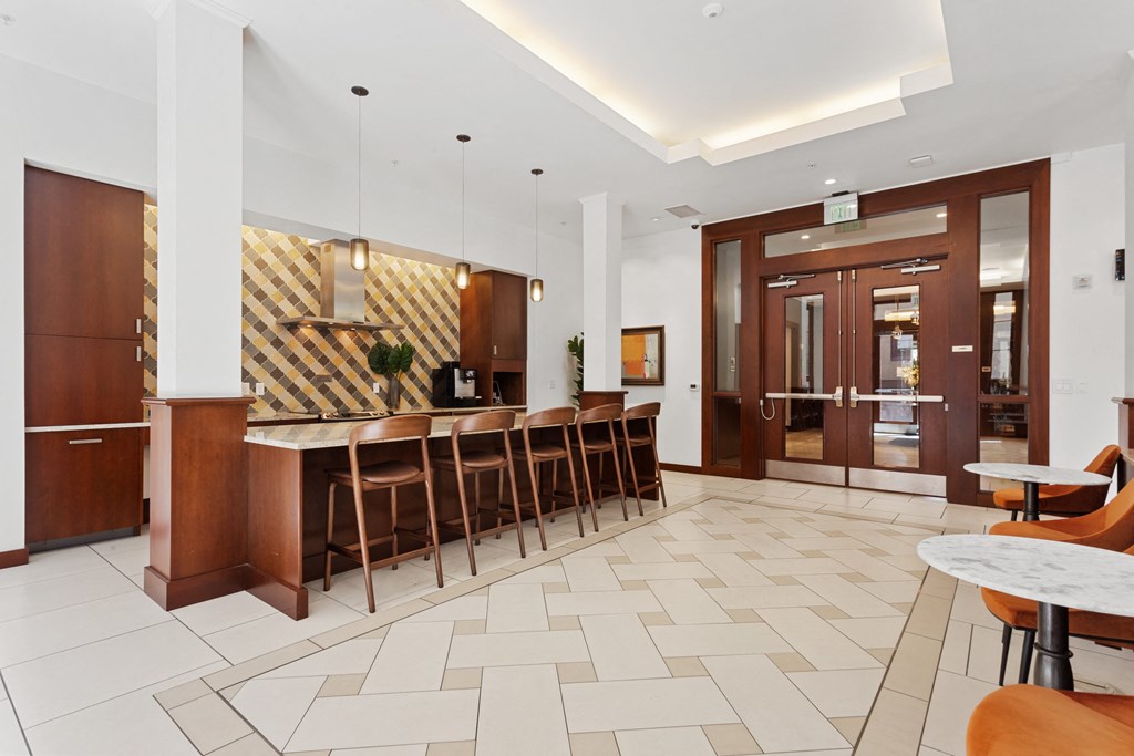 the lobby of a hotel with a bar and tables