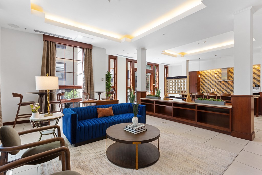 a lobby of a hotel with a blue couch and a coffee table