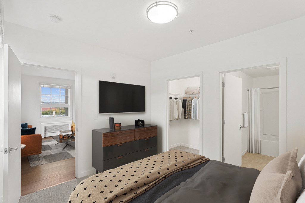 a bedroom with a bed and a tv on the wall