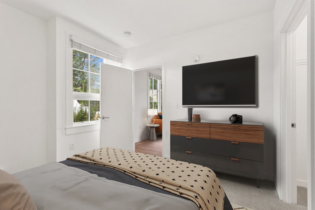 a bedroom with a bed and a television on the wall