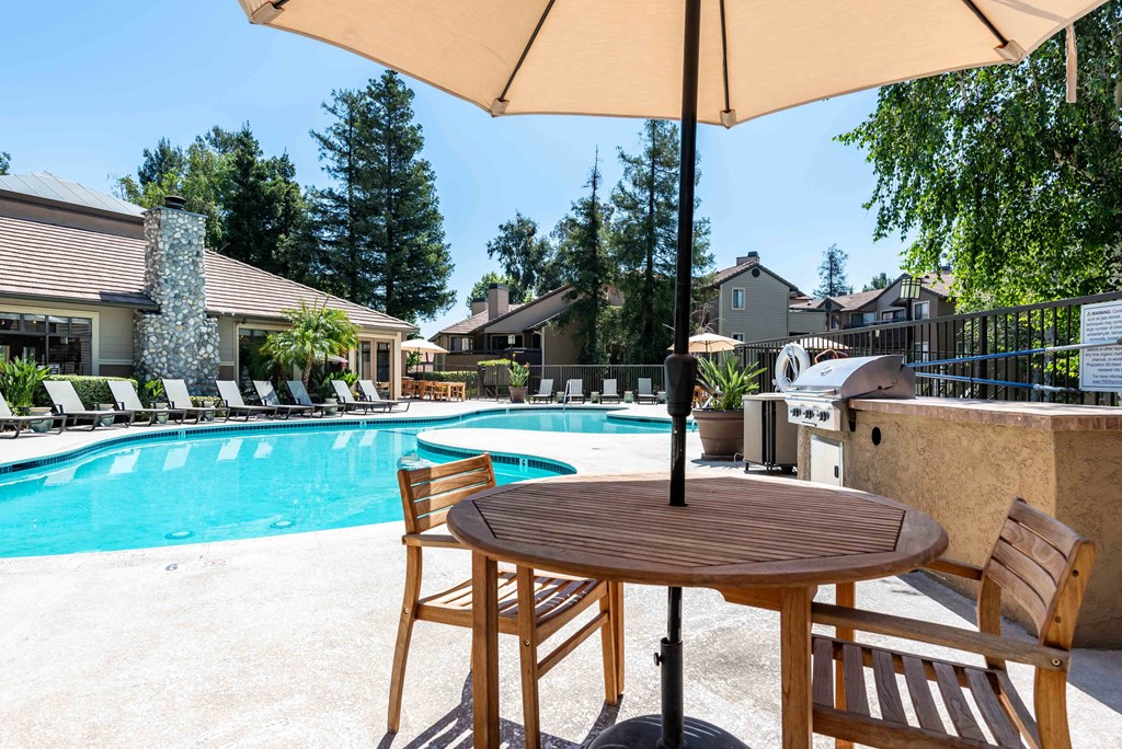 Apartments in Rancho Cucamonga, CA for Rent - Creekside Alta Loma - Resort-Style Pool Surrounded By Lounge Chairs and Greenery