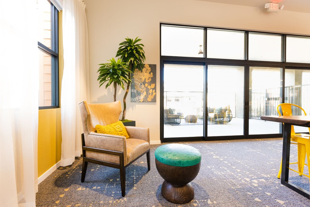 a living room with a chair and a table in front of a window