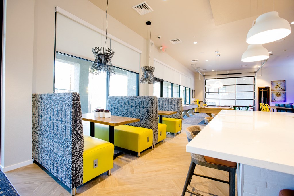 a seating area with yellow chairs and tables in a restaurant