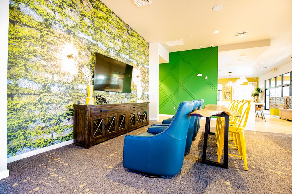 a lobby with blue chairs and a table and a television