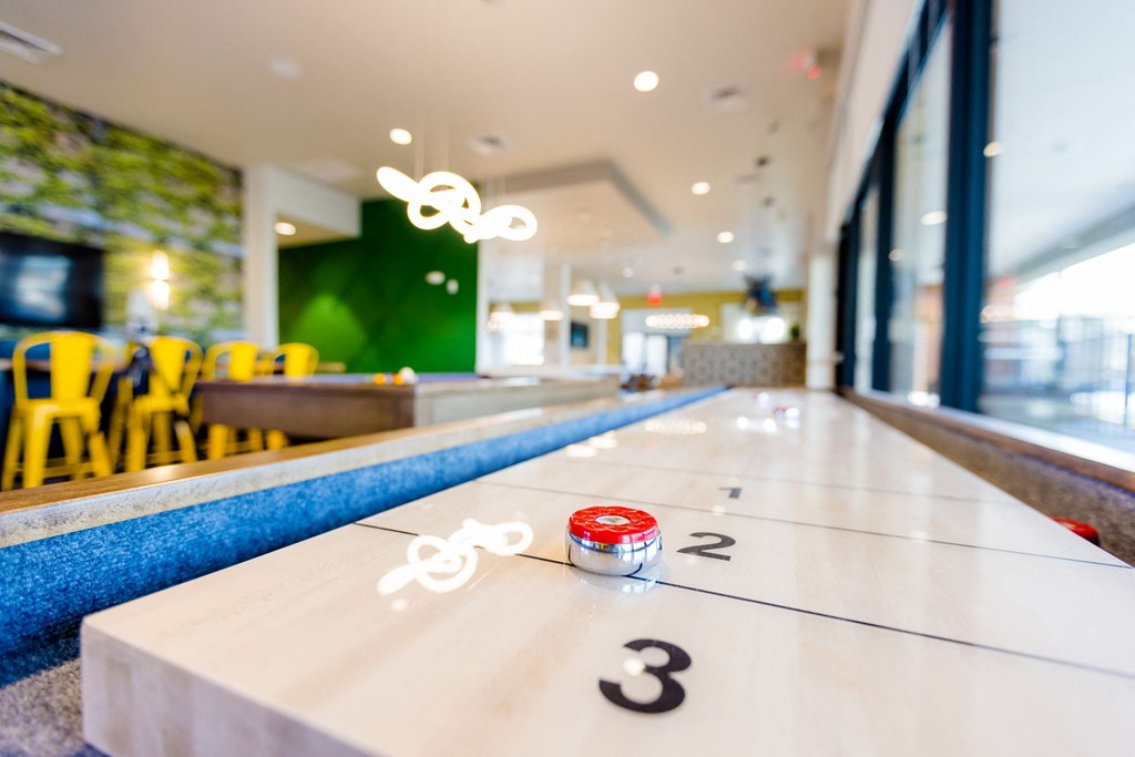a shuffleboard table in a restaurant with three numbers on it