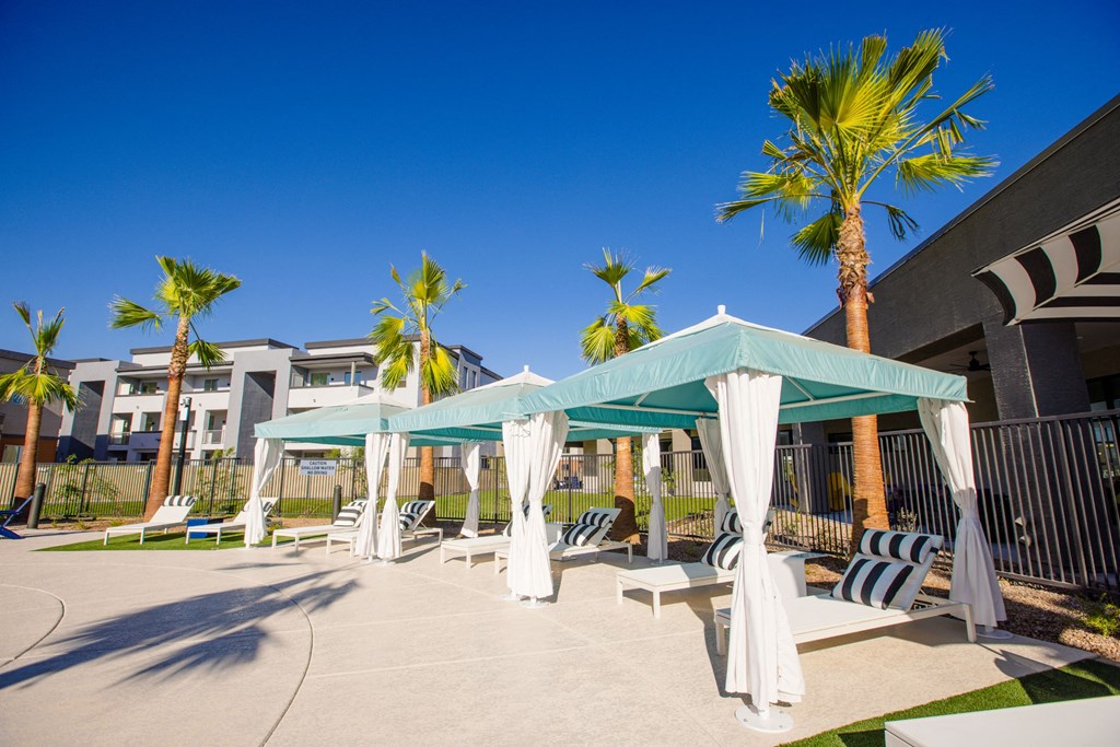 a patio with hammocks and umbrellas at the resort