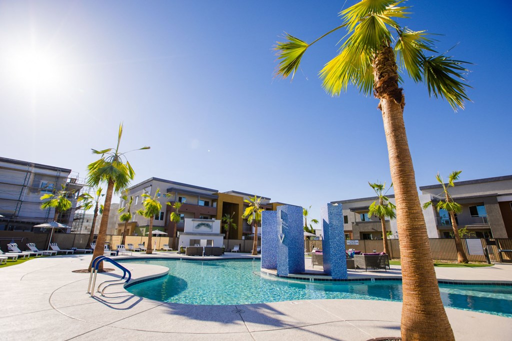 Apartments In Gilbert AZ For Rent - Sparkling Heated Resort-Style Pool With Water Fountains, Lounge Chairs, Hot Tub, Cabanas Beds, And Palm Trees.