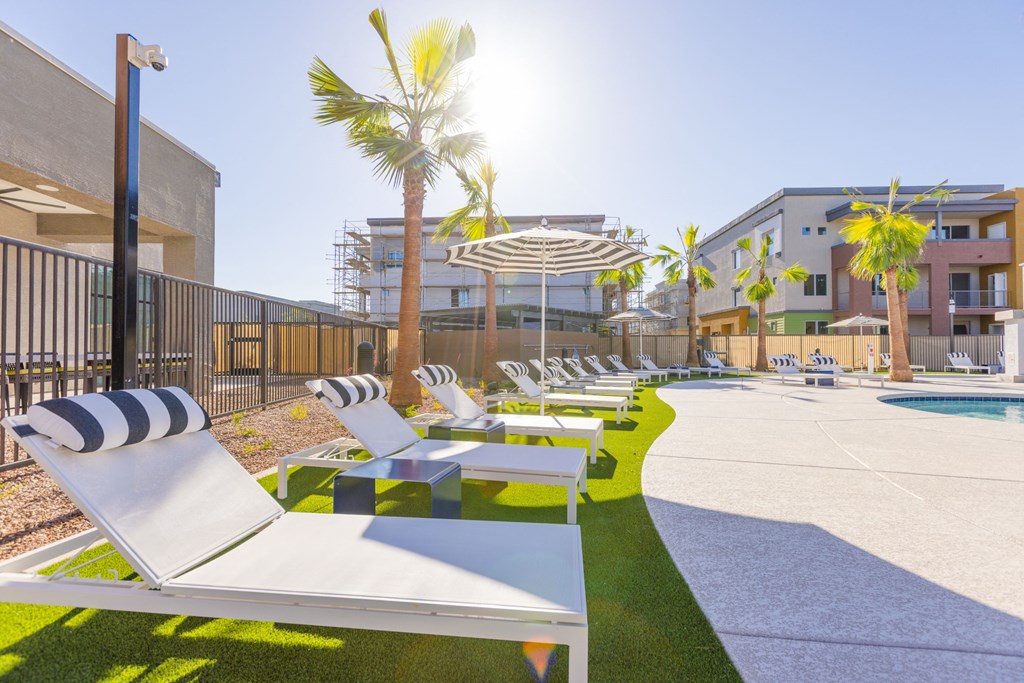 a row of lounge chairs next to a pool in a building