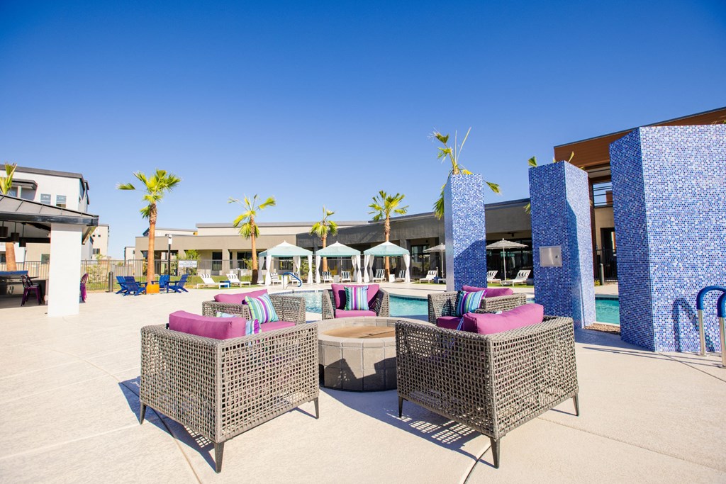 a lounge area with chairs and a pool at a resort