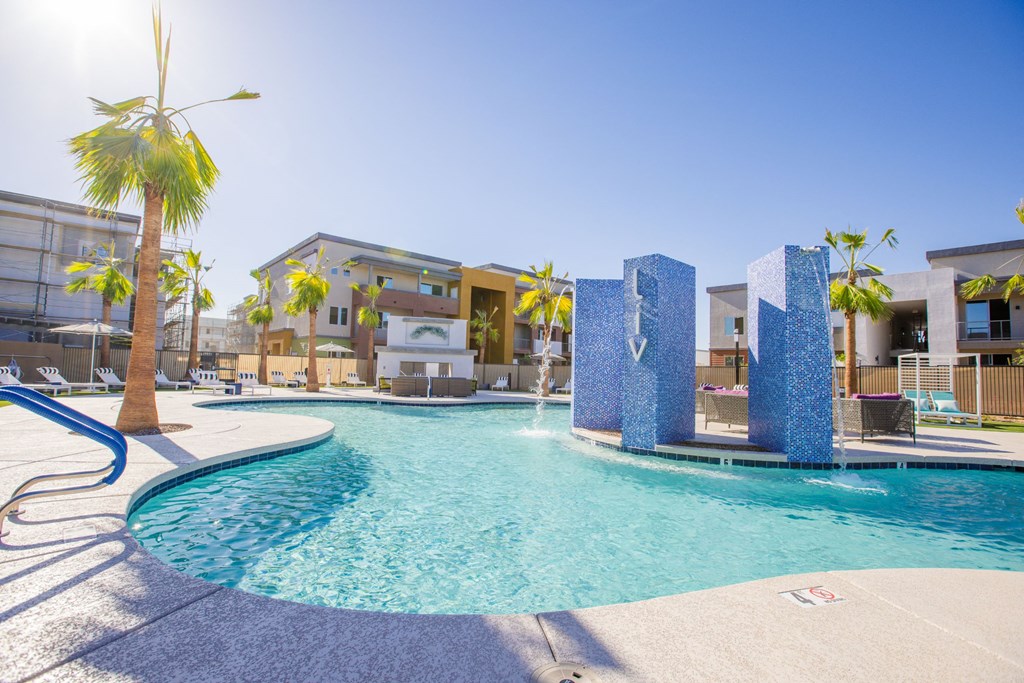 a swimming pool with palm trees and apartments in the background