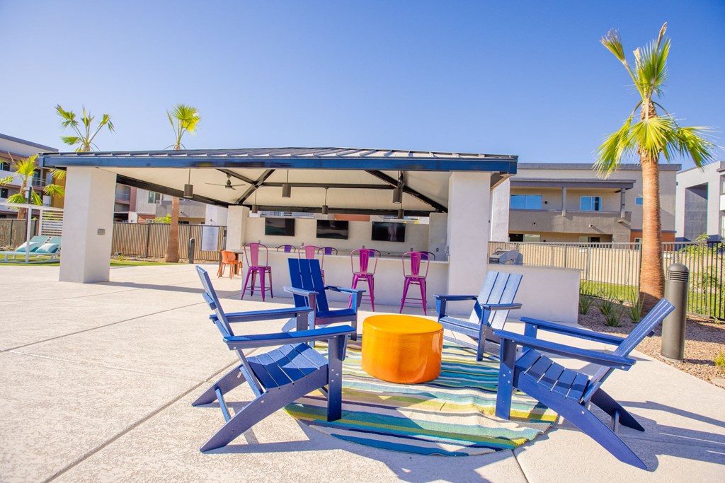 a patio with blue chairs and a table and a canopy