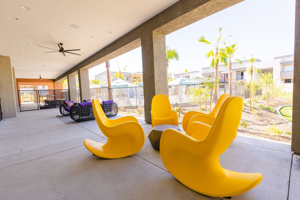 furnished lobby with yellow chairs and a view of palm trees
