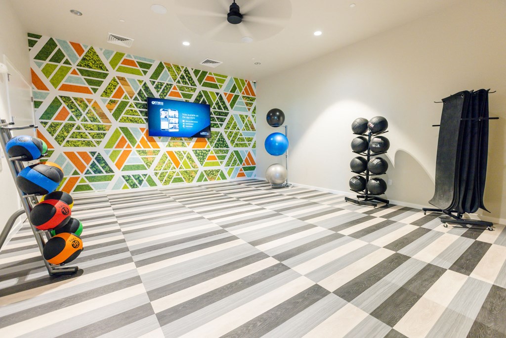 a gym with a checkered floor and a wall with a television