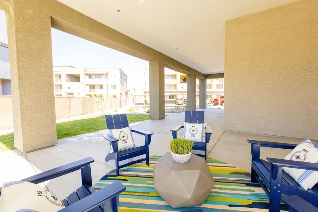 the lobby of a hotel with blue chairs and a colorful rug