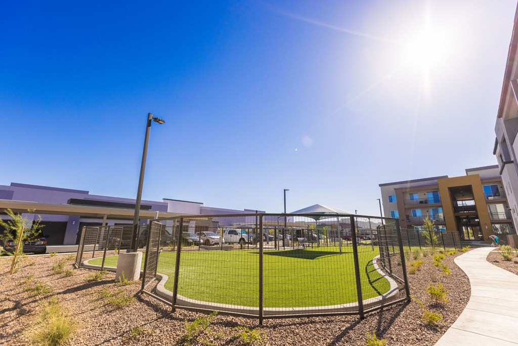 a tennis court in front of a building with a fence