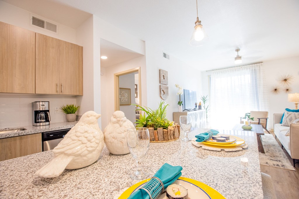 a kitchen and living room with a counter top and a table