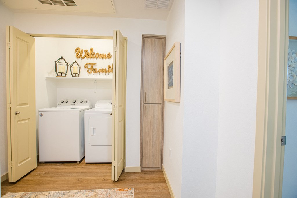a laundry room with a washer and dryer and a sign on the wall