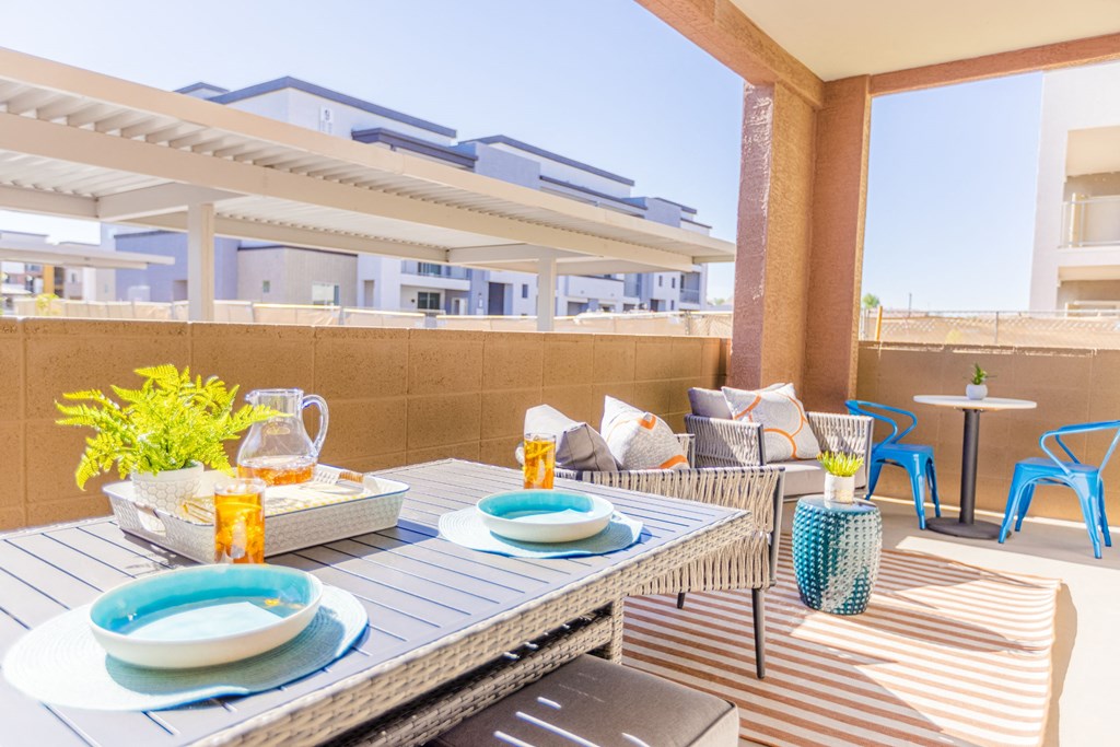 a furnished patio with a dining table and chairs