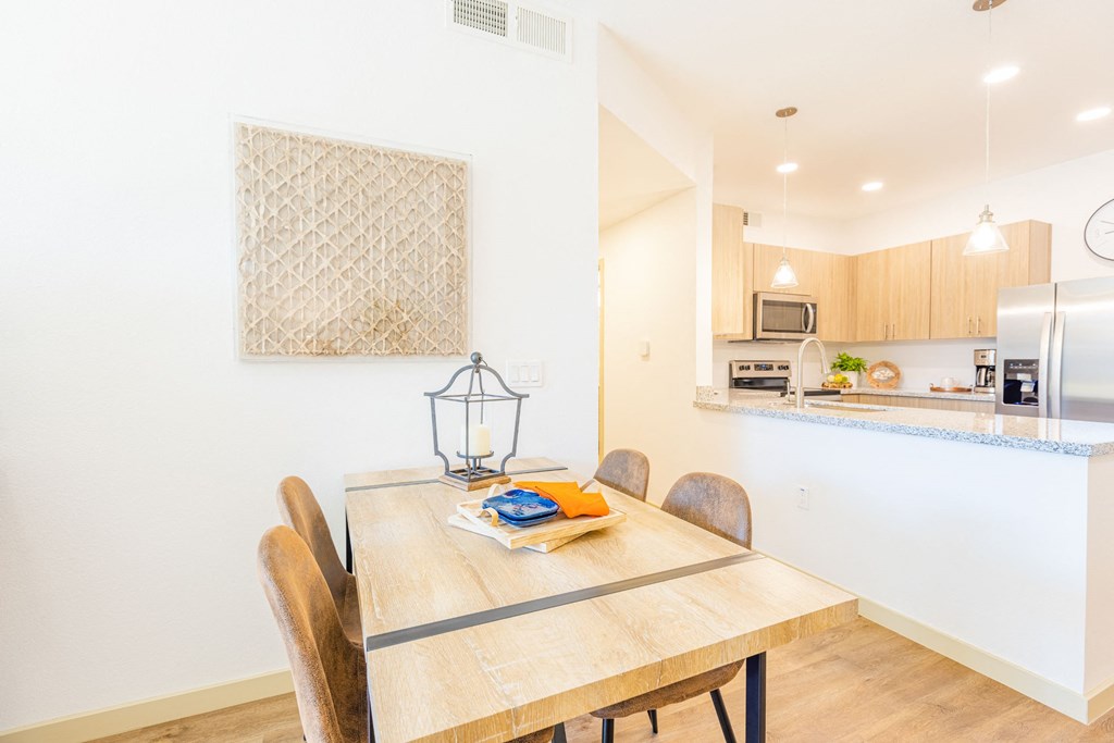 a dining room table with a kitchen in the background