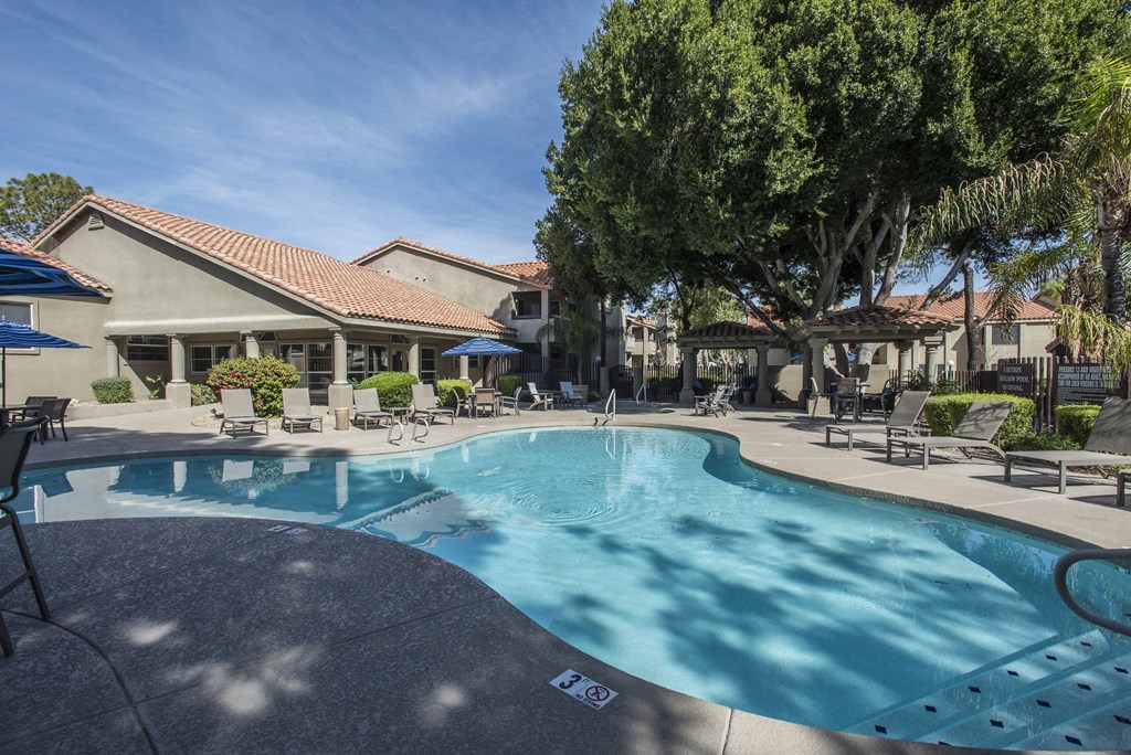 a large swimming pool with lounge chairs around it