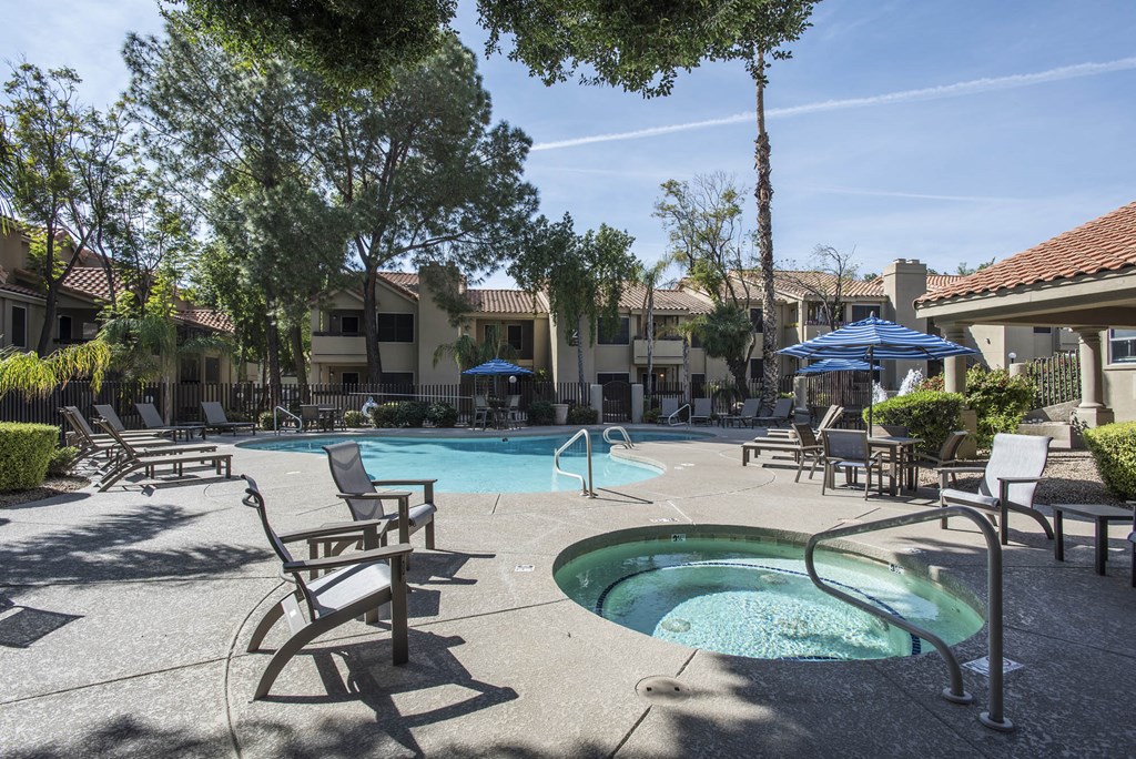 a swimming pool with chairs and a hot tub
