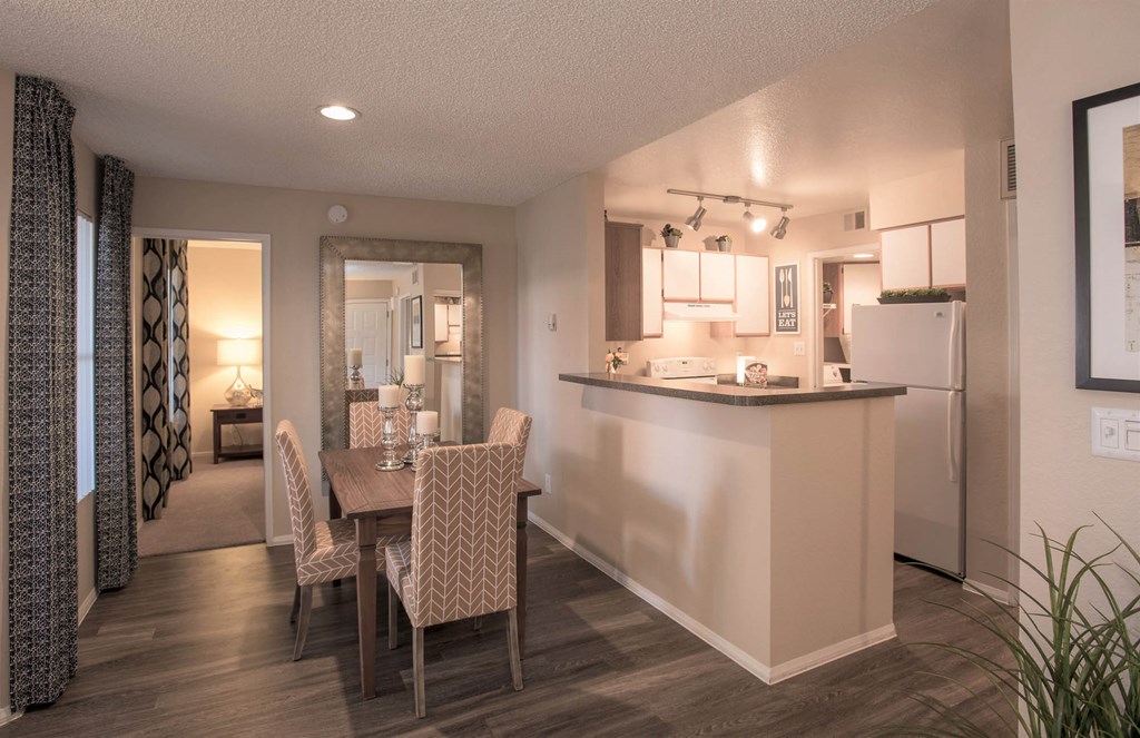 a dining room and kitchen with a table and chairs