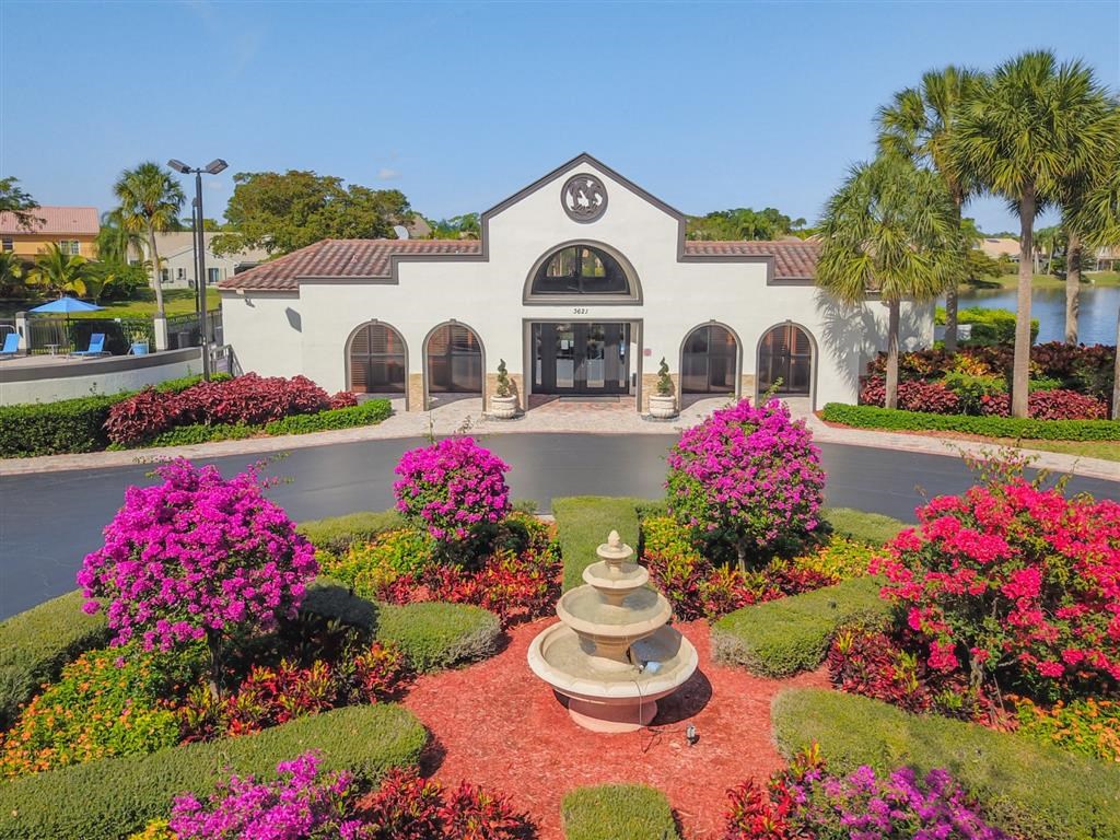 Pet-Friendly Apartments in Coconut Creek, FL – Waterview at Coconut Creek – outside leasing office with water fountain and lots of bushes with pink flowers