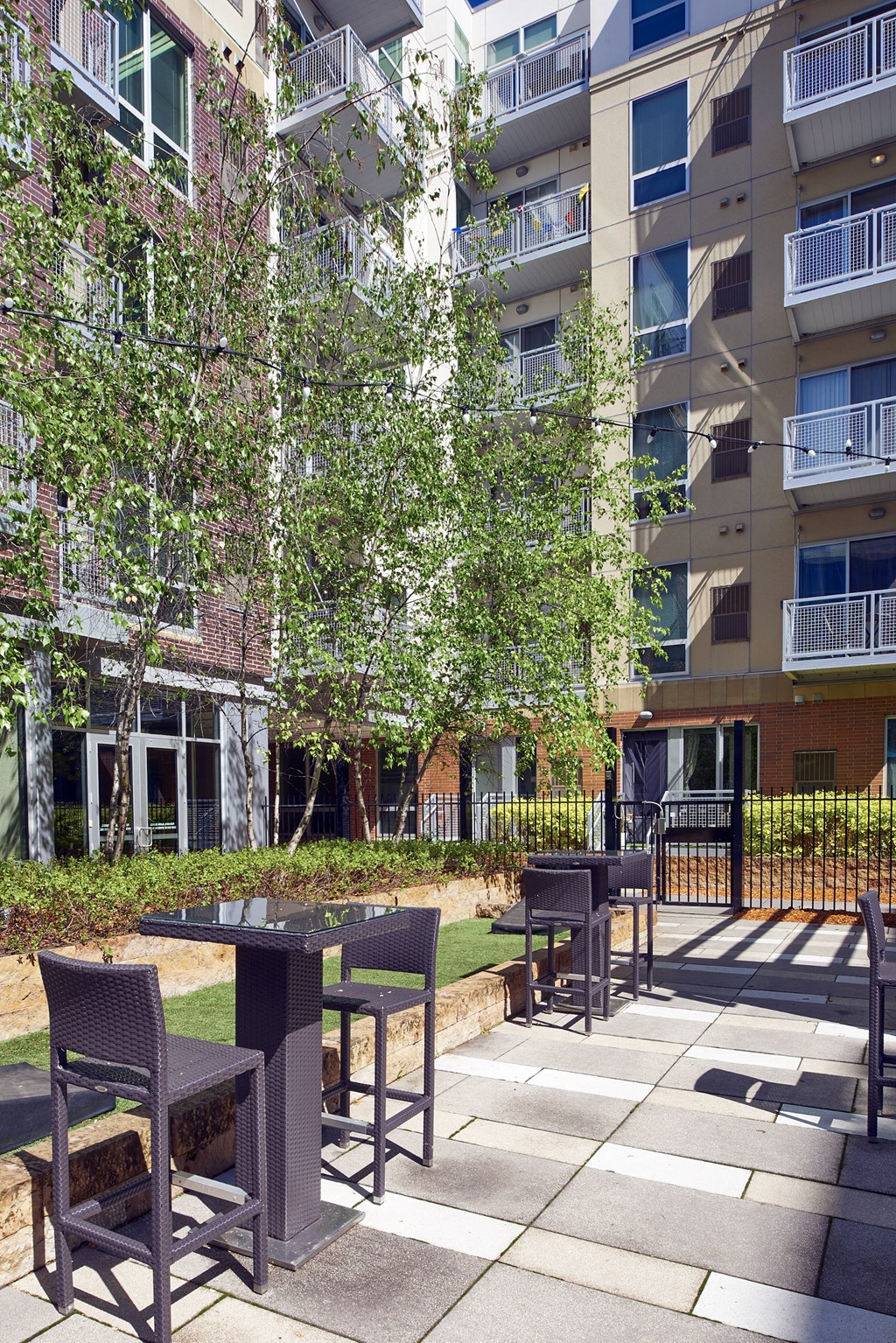 an outdoor patio with tables and chairs in front of an apartment building