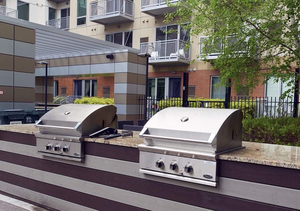 two bbq pits in front of an apartment building
