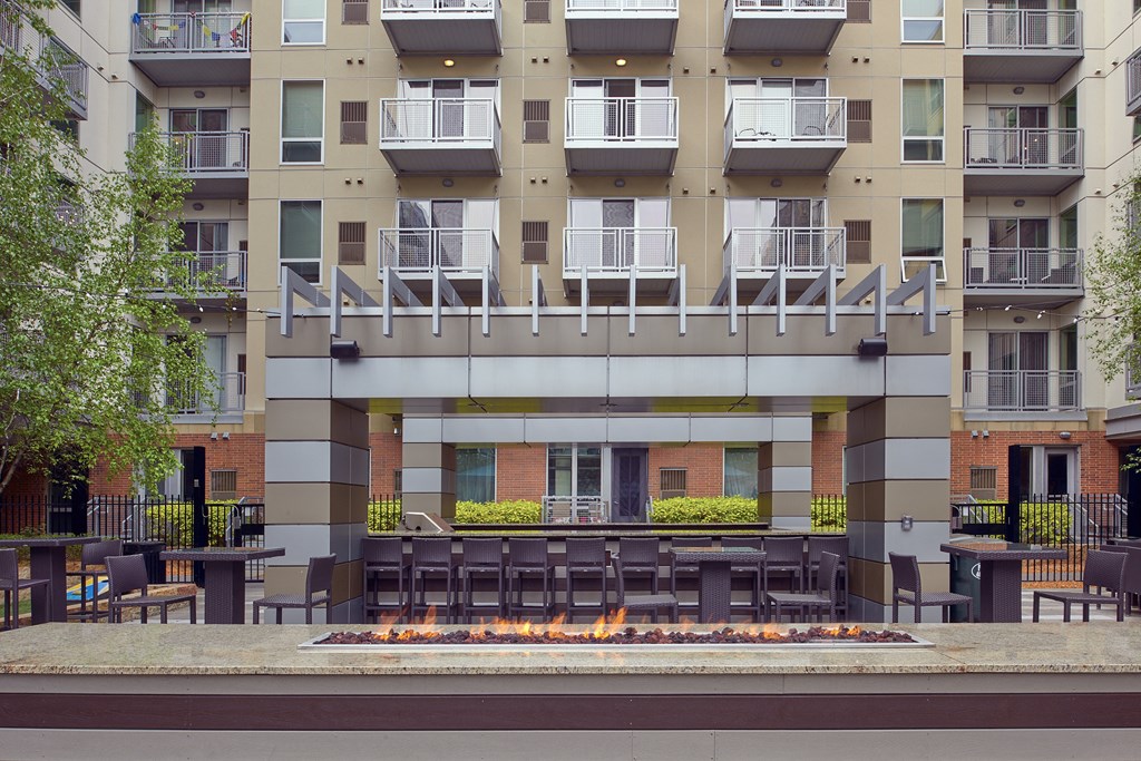 an outdoor patio with tables and chairs in front of an apartment building