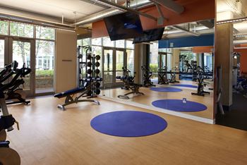 a fitness room with exercise equipment and a tv