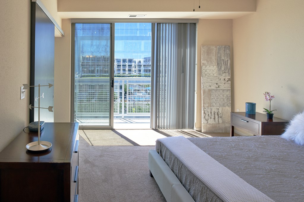 a hotel room with a bed and sliding glass doors