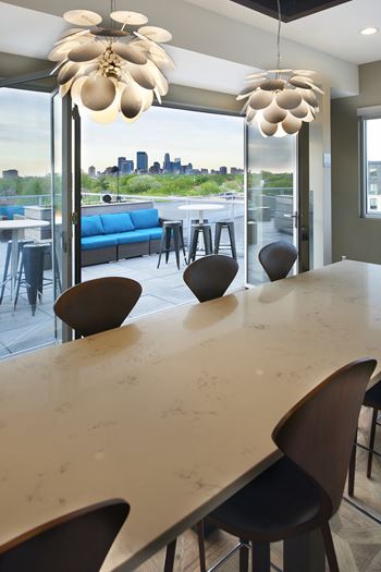 a long dining table with chairs and a view of the city