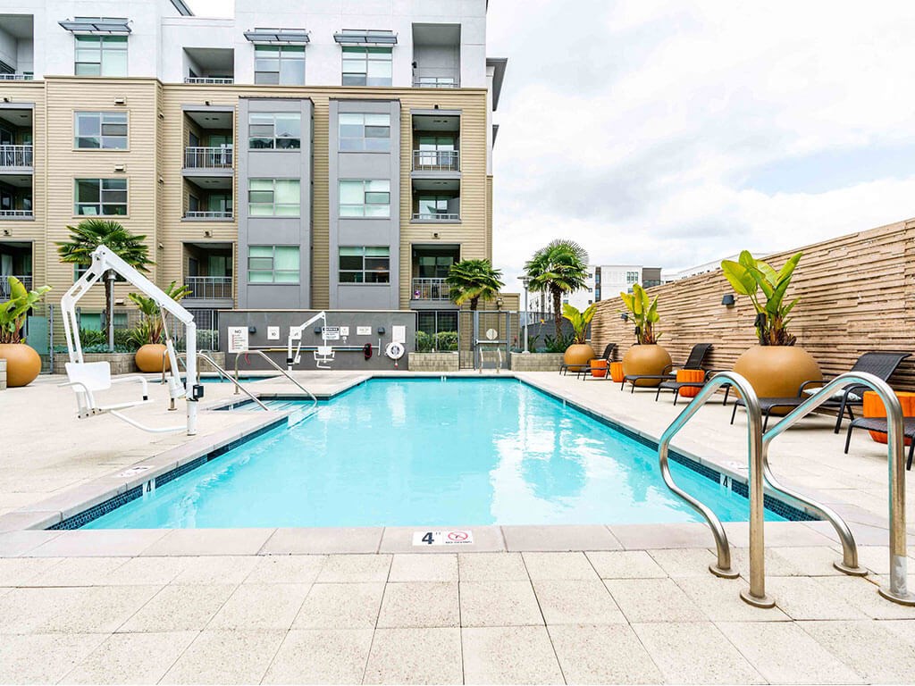 One Bedroom Apartments in Redwood City CA - Franklin 299 - A Sparkling Pool With Lounge Chairs, Tables, Hot Tub, And Plants.