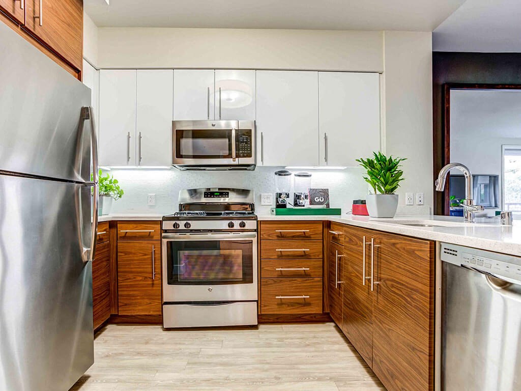 Apartments Redwood City - Franklin 299 - Kitchen With Quartz Countertops, Stainless Steel Appliances, Wood-Style Cabinets and White Cabinets