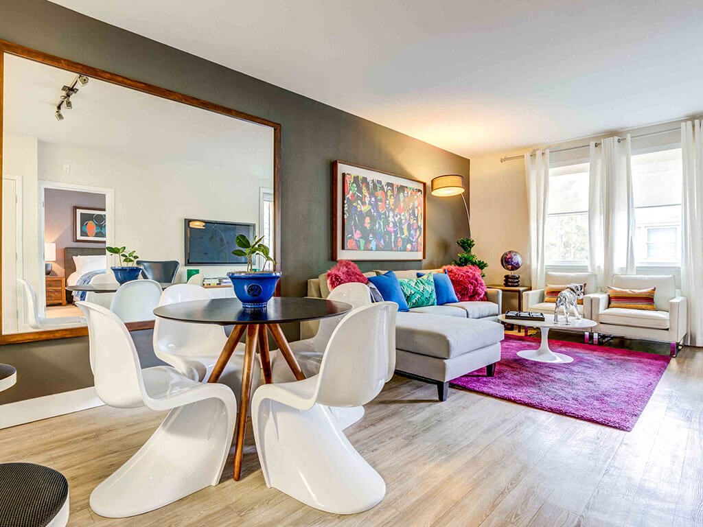 Redwood City Luxury Apartments - Franklin 299 - Furnished Living Room With Wood-Style Plank Flooring, Windows, A Dining Area, And Stylish Decor.