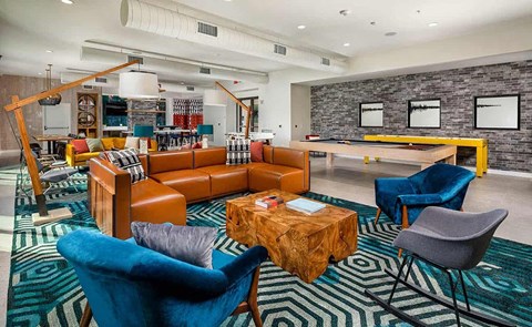 a lobby with couches chairs and a pool table