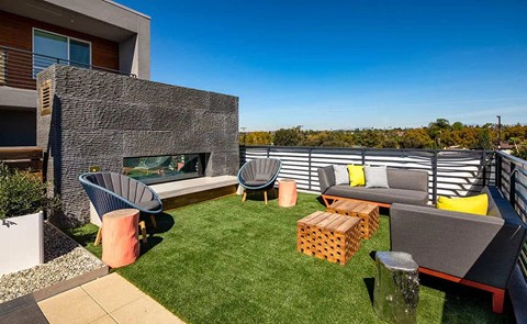 a backyard patio with chairs and a fireplace