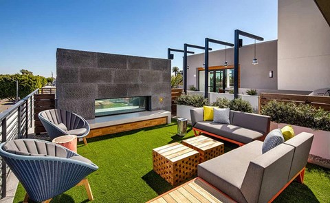 a furnished patio with chairs and a fireplace